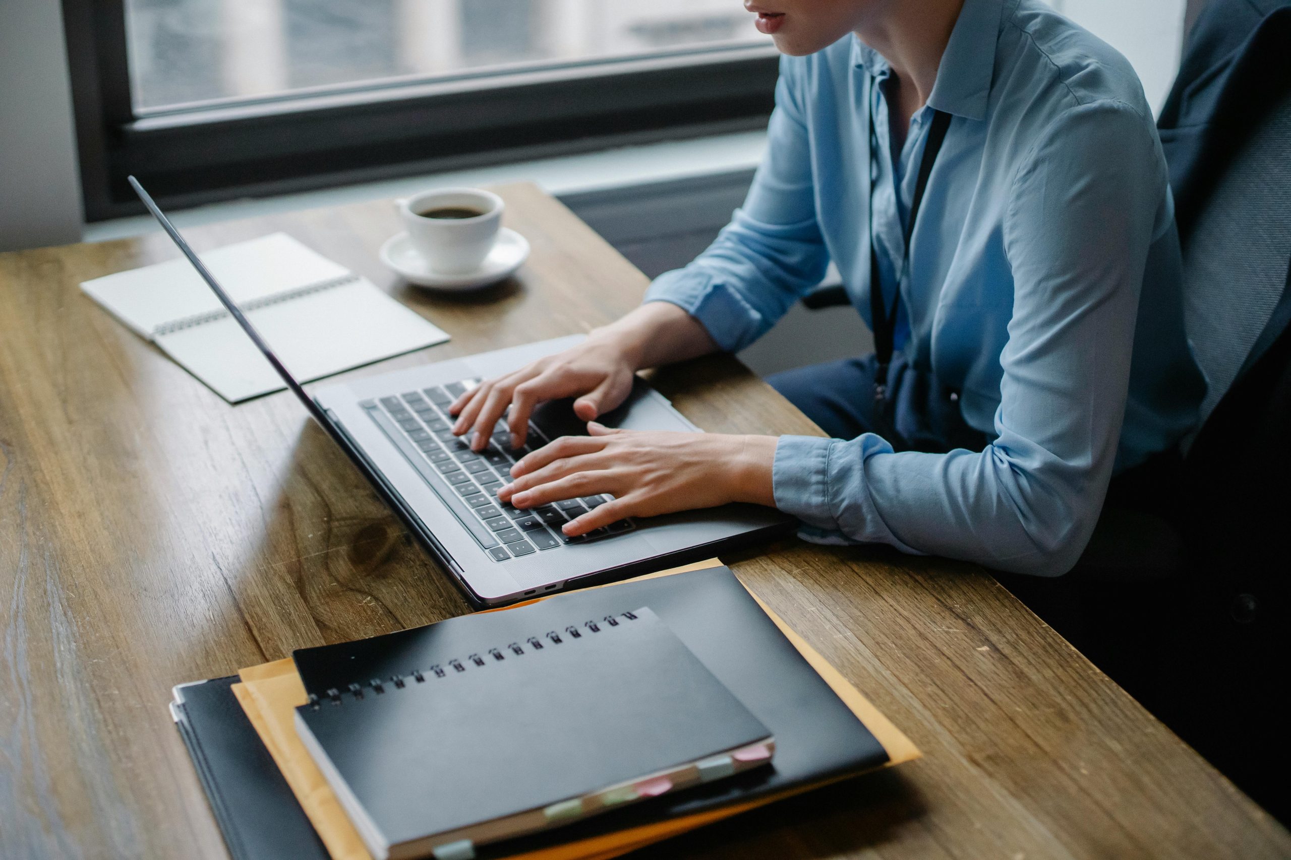 Image of a business person working on a laptop computer at a desk in an office environment